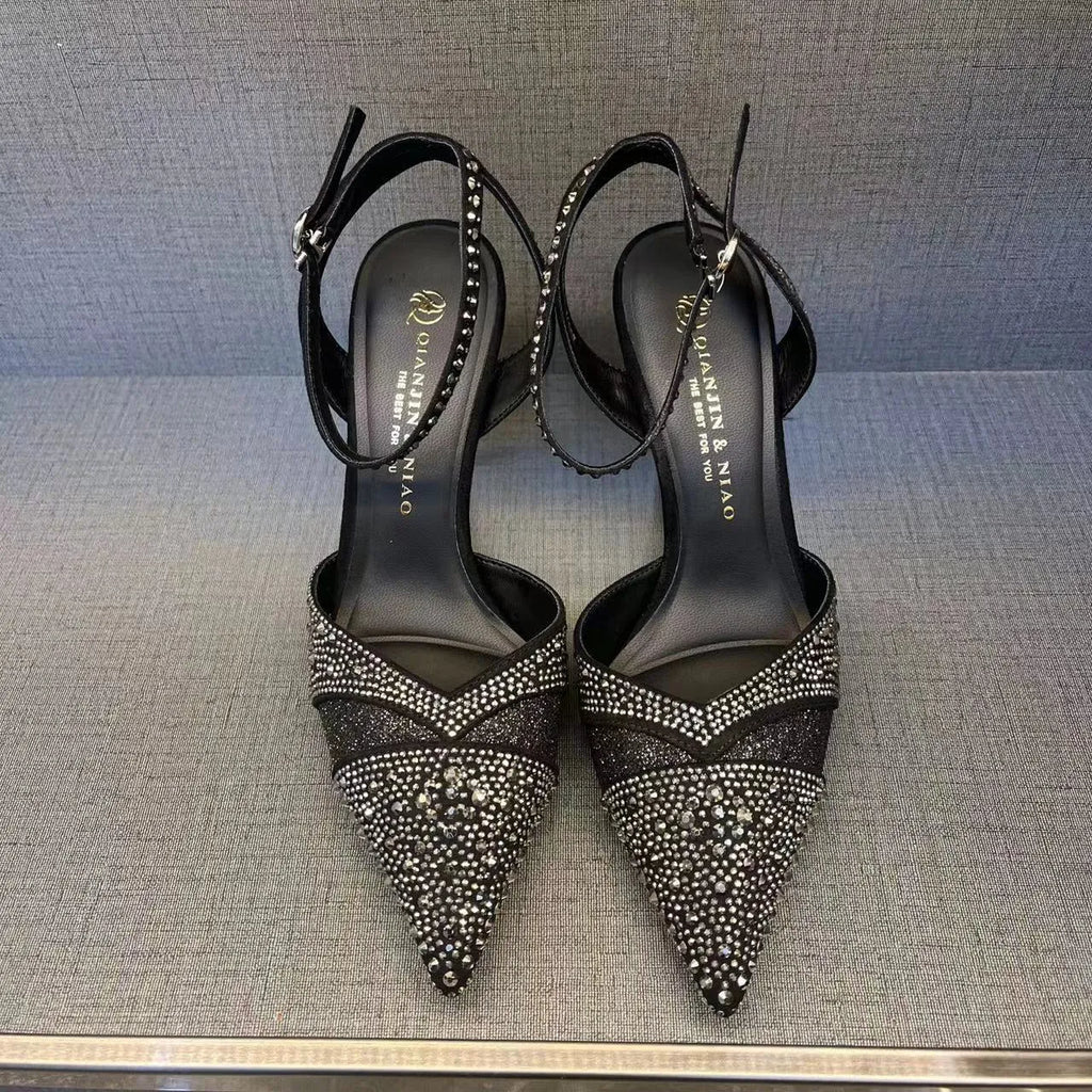 Women's black high heels with hollow design, red sole, and pointed toe on stiletto heel
