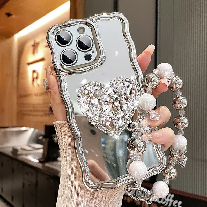 Silver grey silicone iPhone case with mirror finish, rhinestone bracket, and wrist strap lanyard.