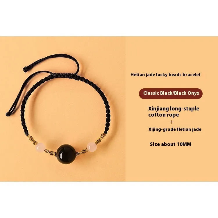 Hand-woven red rope bracelet with Hetian jade beads and intricate charm detailing.