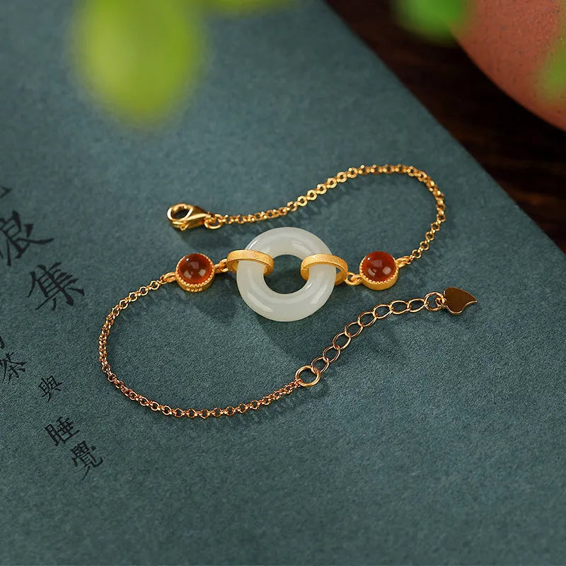 Women's sterling silver bracelet with gold-plated finish and natural Hetian jade peace buckle on adjustable chain