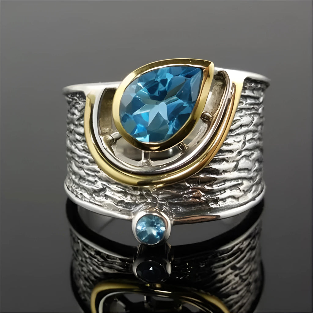 Blue drop-shaped women's alloy ring with inlaid zircon rhinestones on a finger.