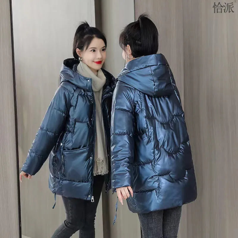 Green loose thick hooded women's winter jacket on a hanger, showing long sleeves and front zip.