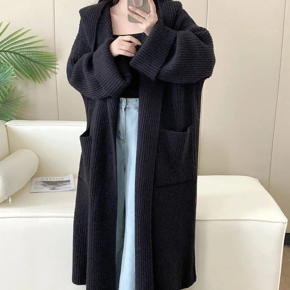 Women's loose grey hooded longline acrylic cardigan coat with raglan sleeves laid flat