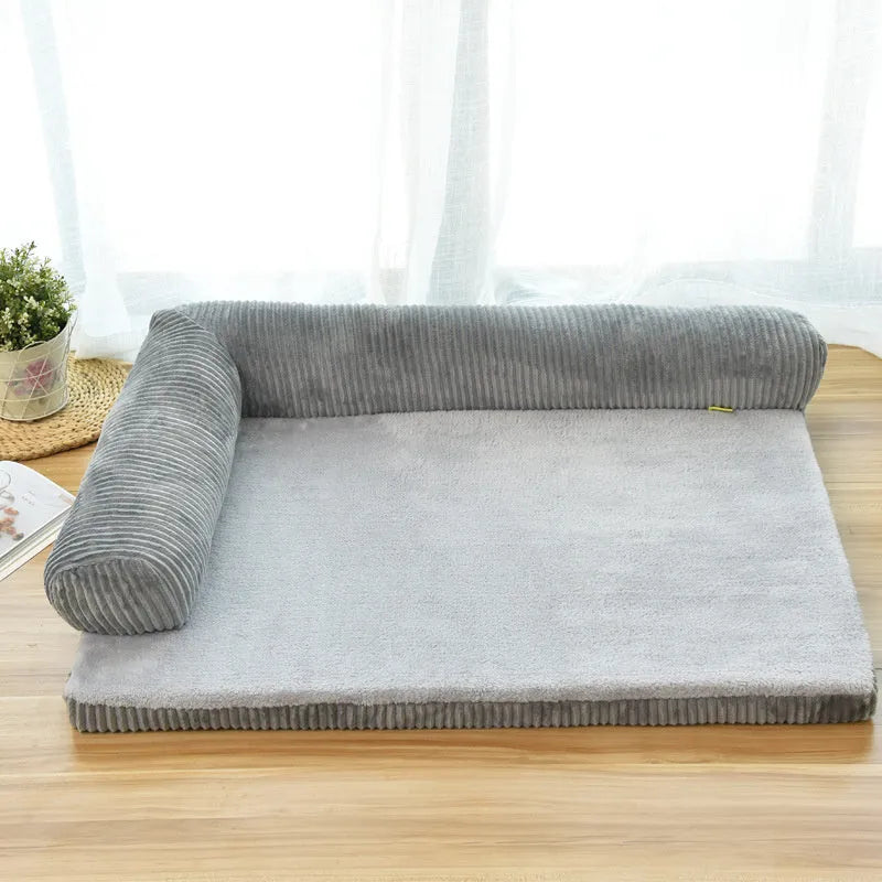 A corduroy dog sofa bed with raised sides in a grey colour, shown on a wooden floor.