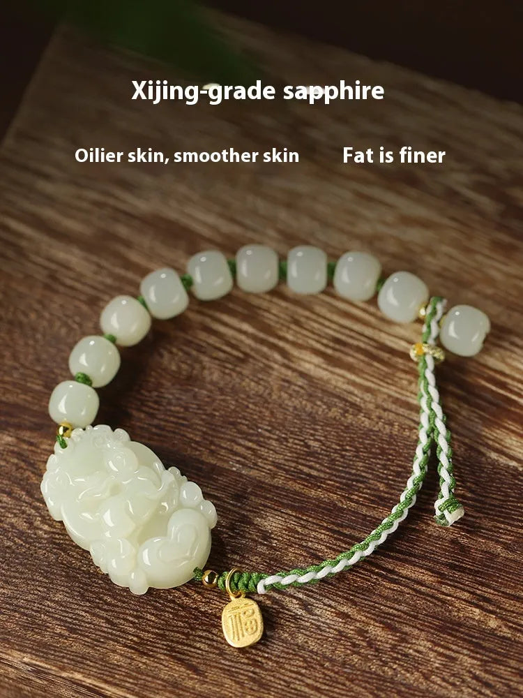 Year of Rabbit red rope bracelet with Hetian jade bead and S925 silver card on a white background.