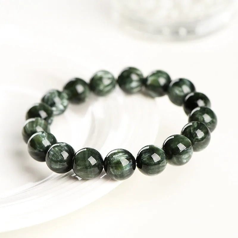 Green dragon crystal bracelet with round beads and a ruyi charm on a wrist.