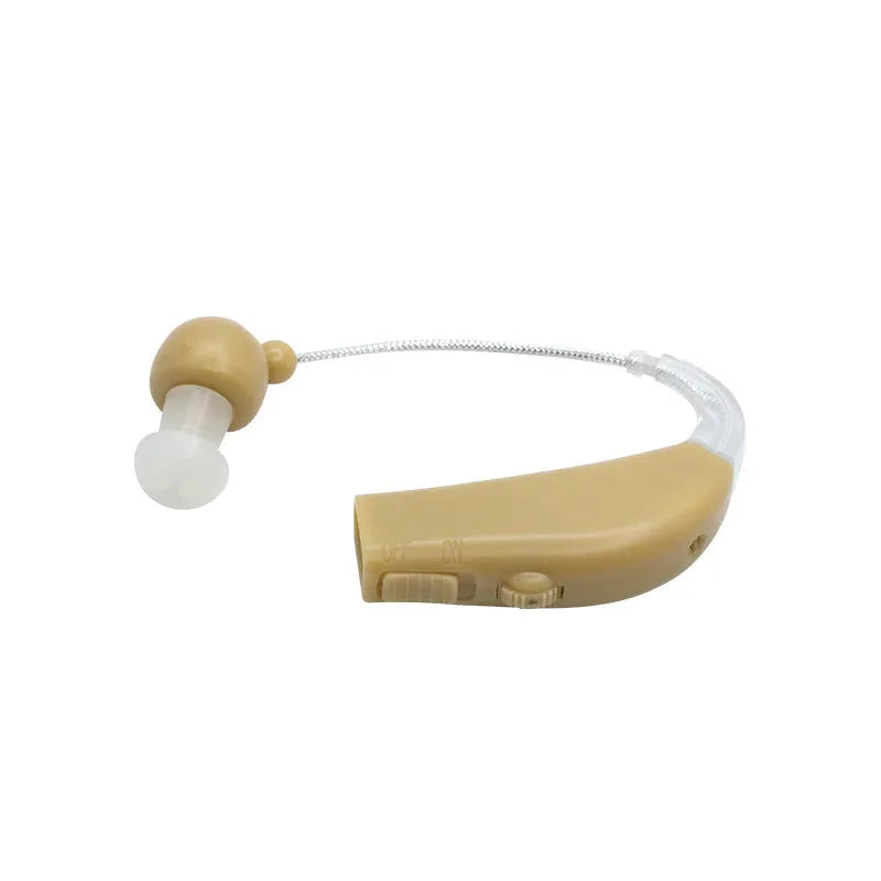 Black silicone rechargeable hearing aid amplifier with charging cable on a table.