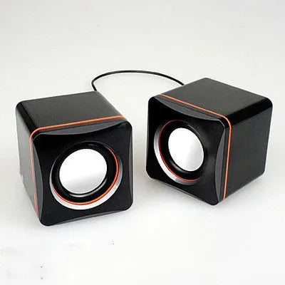 Black square USB-powered 2.0 desktop computer speaker on a desk.