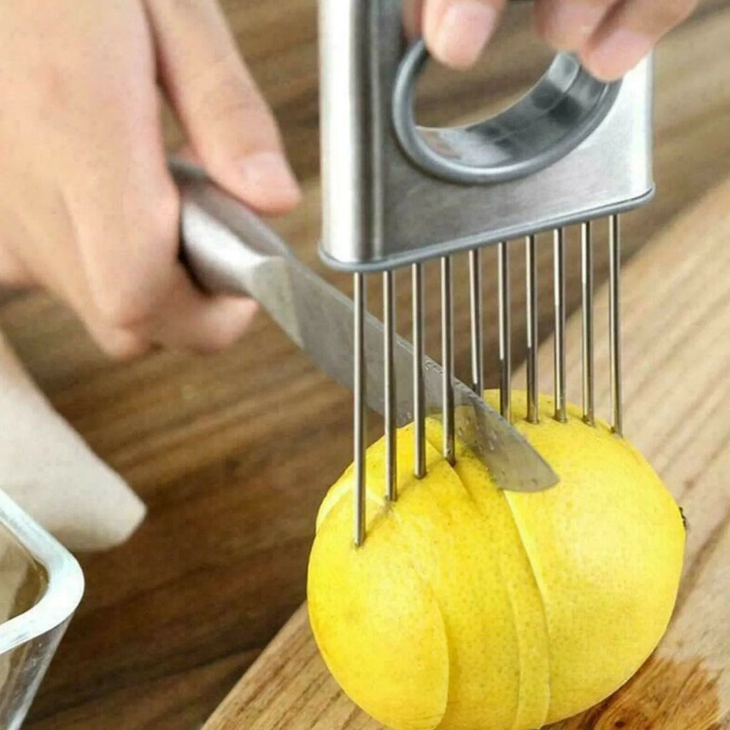 Stainless steel onion holder with sharp prongs and a red finger guard on a kitchen counter.