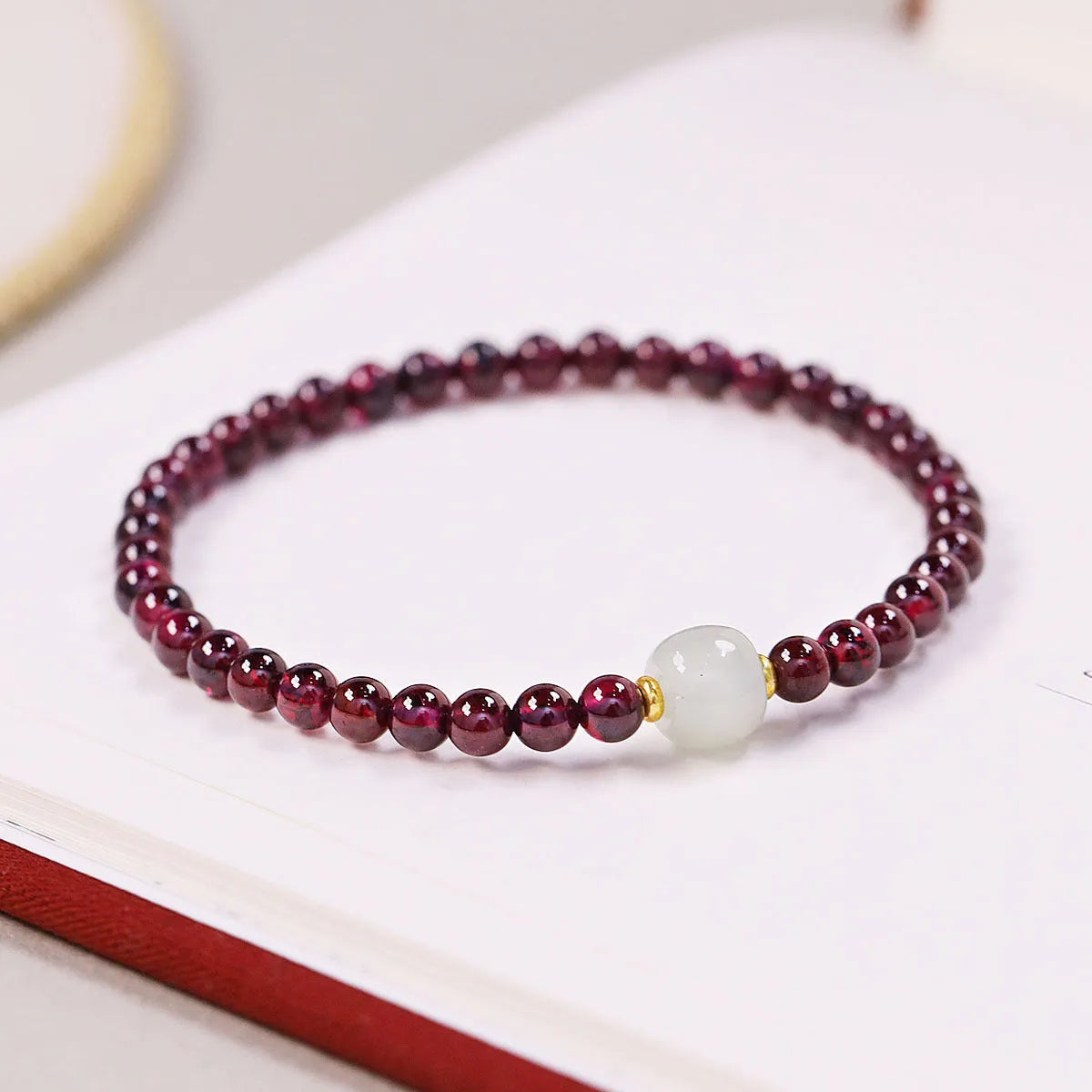 Women's garnet bracelet with U-shaped design showing polished stones in garnet colour