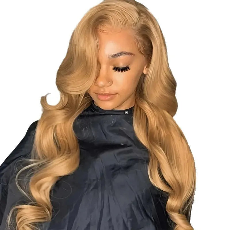 Light brown long curly synthetic wig with big waves and side bangs displayed on a stand.