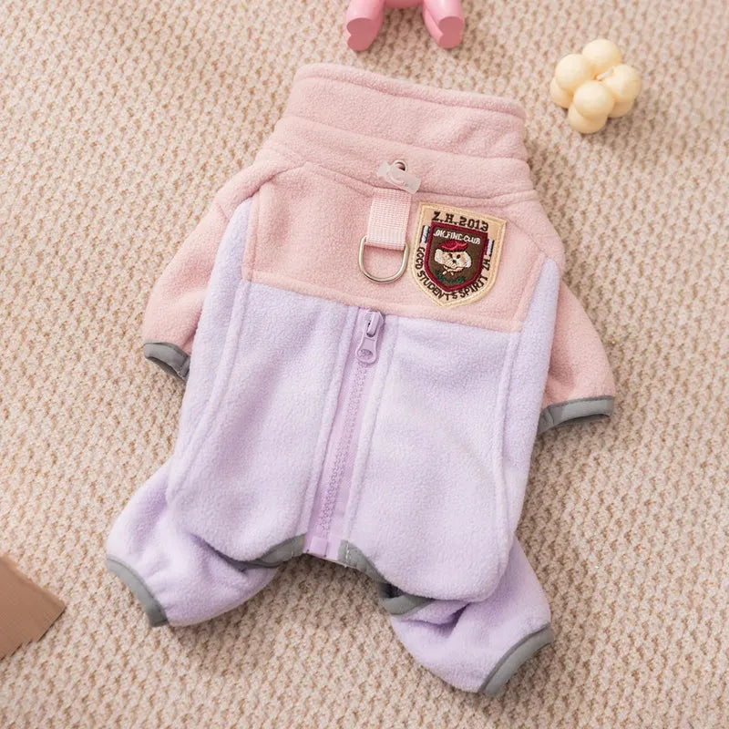 Small dog wearing a colour-block fleece jumpsuit in purple and pink, with full-zip front and leash ring