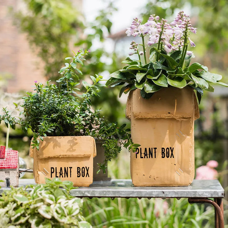 Cement flowerpot with brown paper carton design and drainage hole for indoor balcony plants.