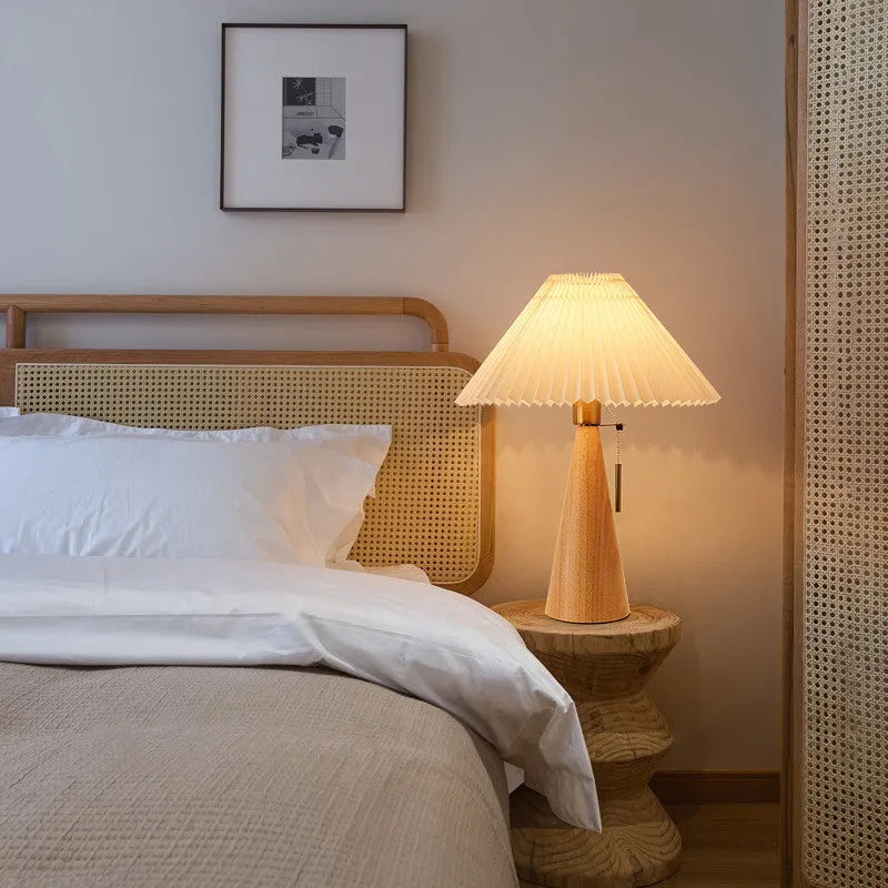 Handmade walnut wood small table lamp with beige pleated cloth shade and LED light on a desk