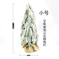 Small 24-inch artificial Christmas tree with lights and snow finish on desktop