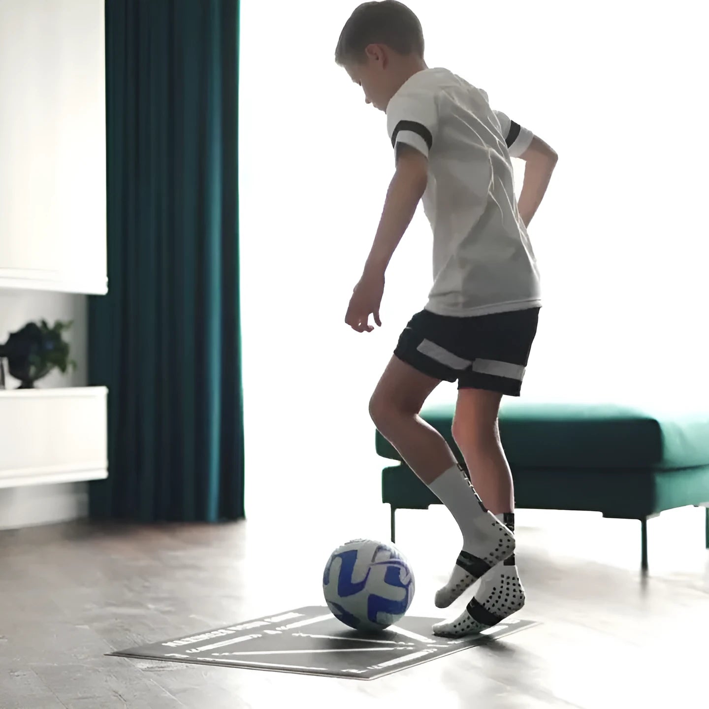 Black non-slip football training mat measuring 60 by 90 centimetres laid flat.