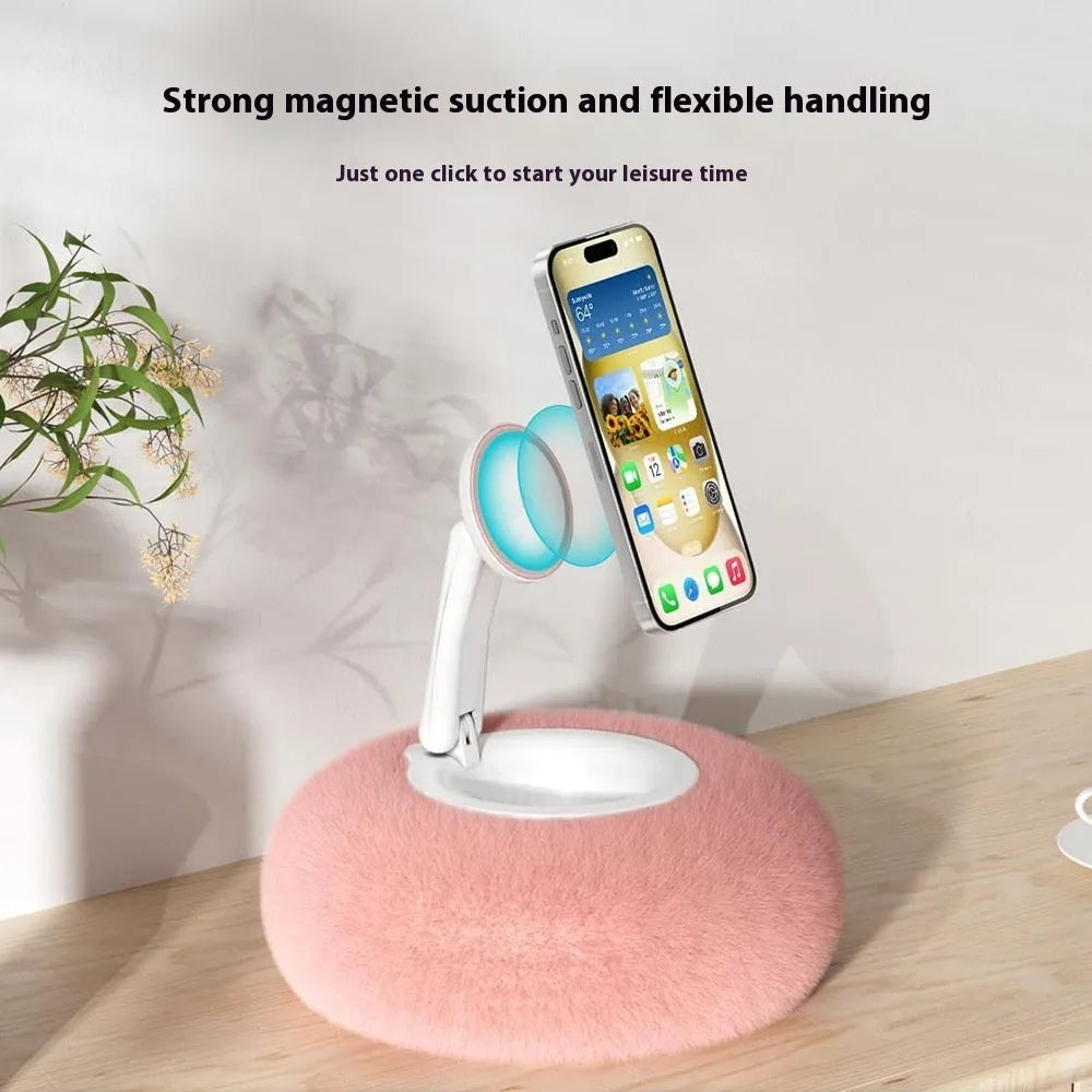 Magnetic mobile phone pillow bracket stand in pink, creamy-white, and khaki green on a bedside table