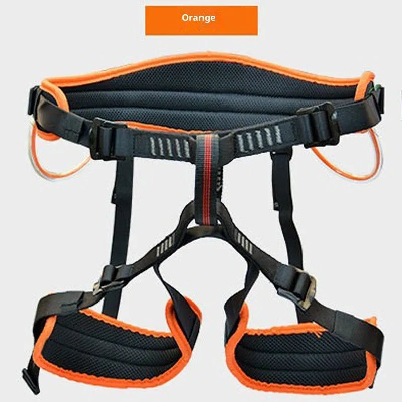 Orange half seat belt climbing safety belt with adjustable waist and leg straps on outdoor rock background