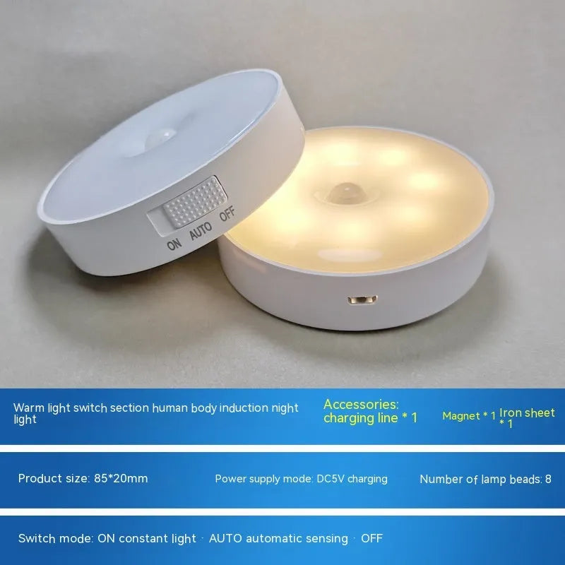 Small round beige and white LED motion sensor night light with USB charging cable.