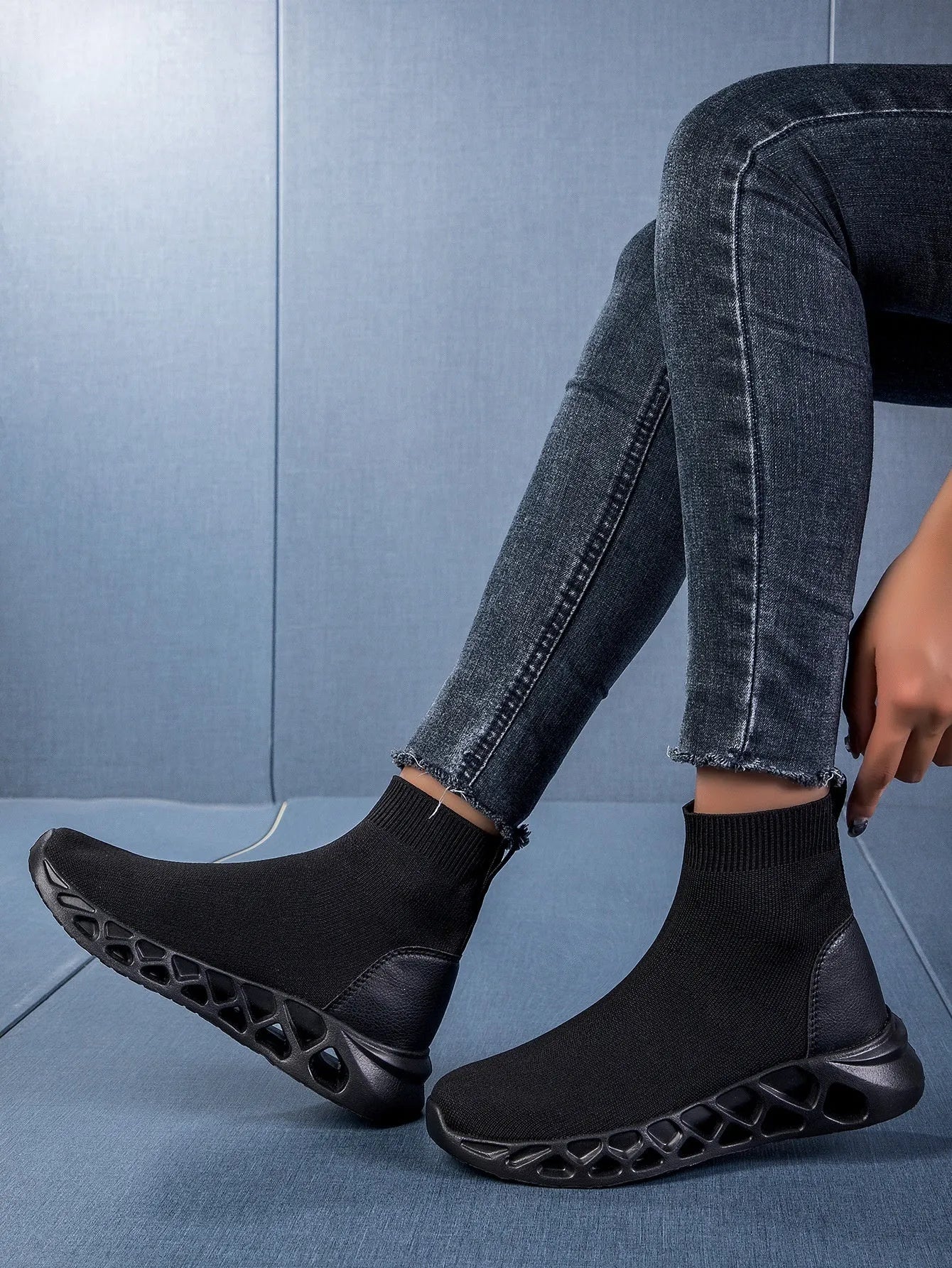Women's black mesh slip-on casual shoe with a low-top, sock-like ankle design and flat sole.