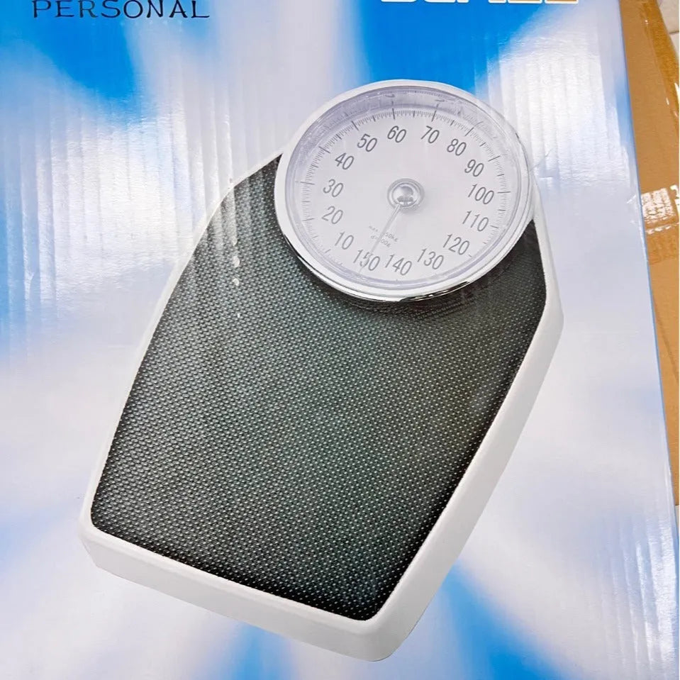 Black mechanical bathroom scale with analogue dial showing weight measurements