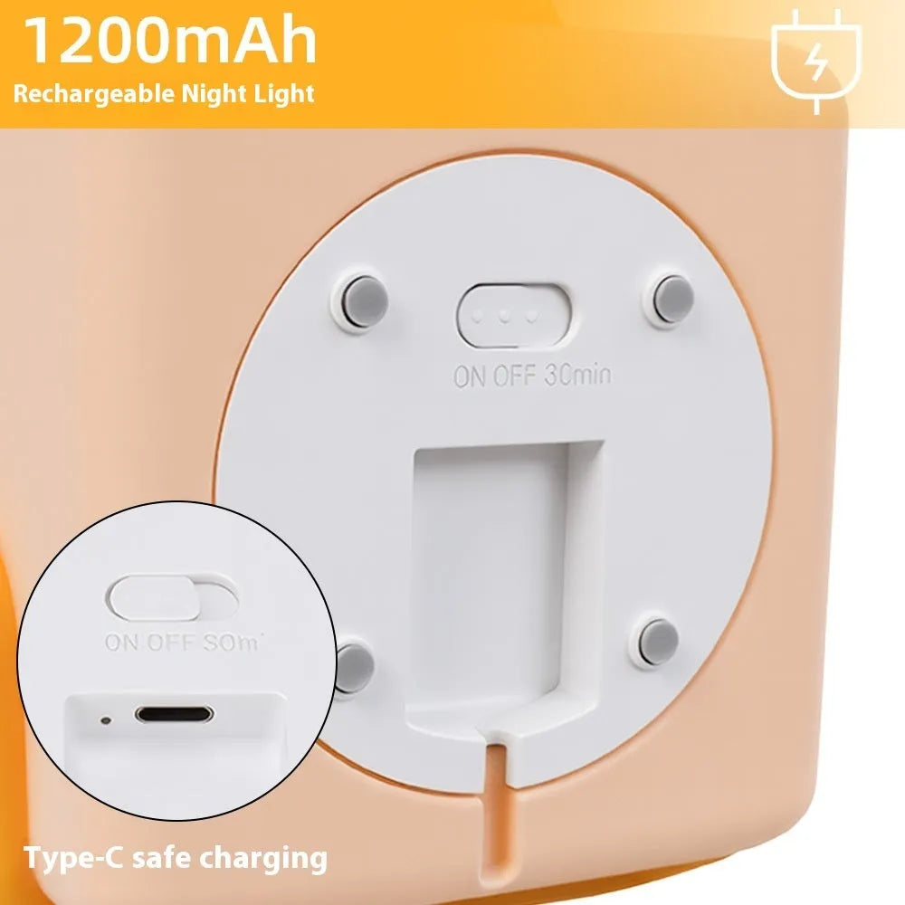 Yellow soft silicone pat lamp with USB charging port on a wooden table showing night light glow