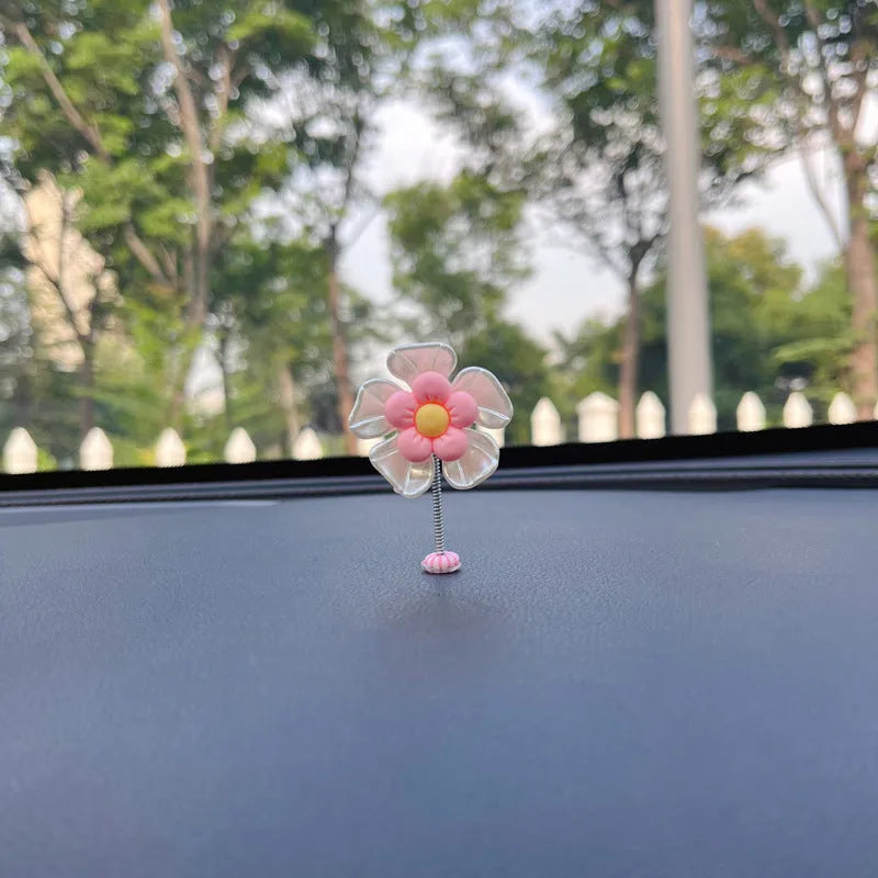 Small blue plastic swing decoration for a car dashboard, shown next to a coin for scale.
