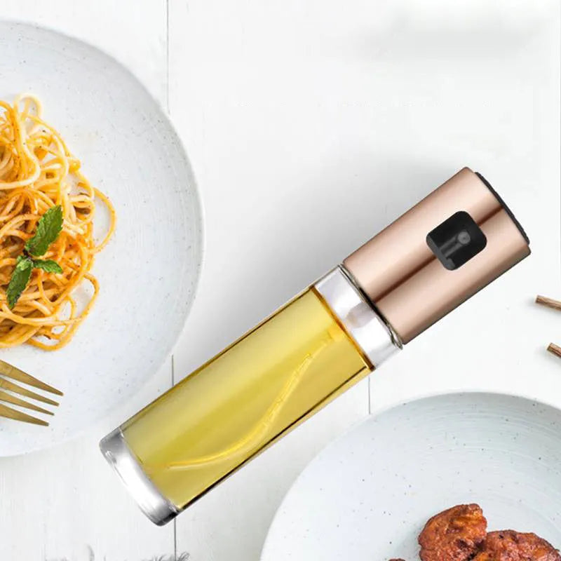 Gold ABS and glass oil and vinegar spray bottle with push-type pump, 17.5cm tall.