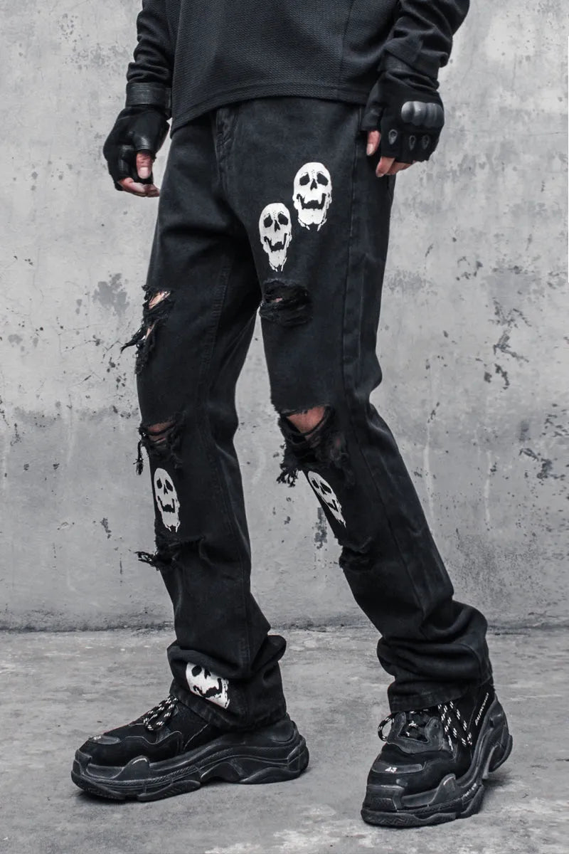 Black cotton denim jeans with skull and crossbones distressed design, mid waist, fit flared horn trousers for men.