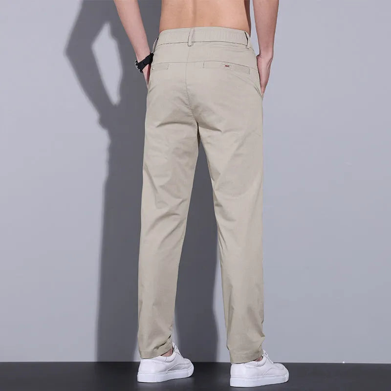 Men's light khaki straight fit cotton casual trousers laid flat, showing slim business casual styling.