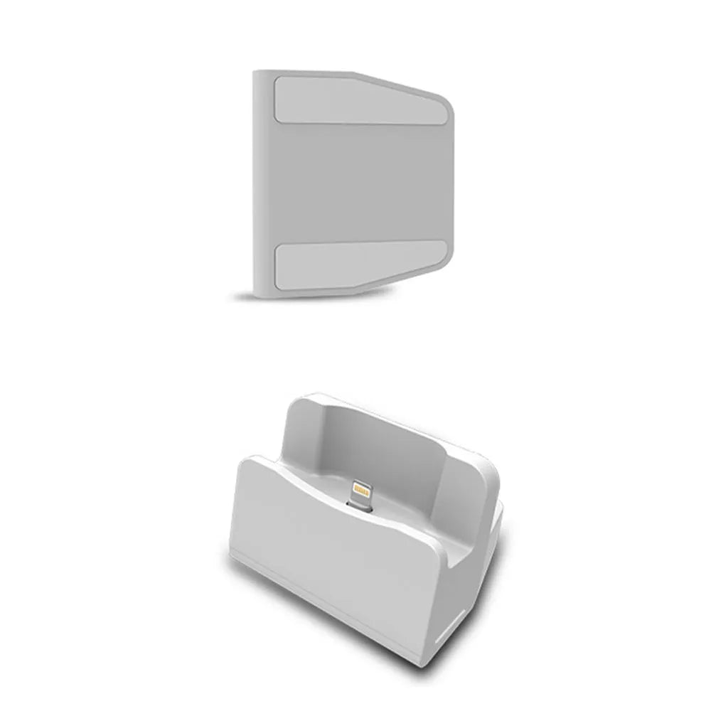 White headphone charging base station on a desk, holding a pair of over-ear headphones.