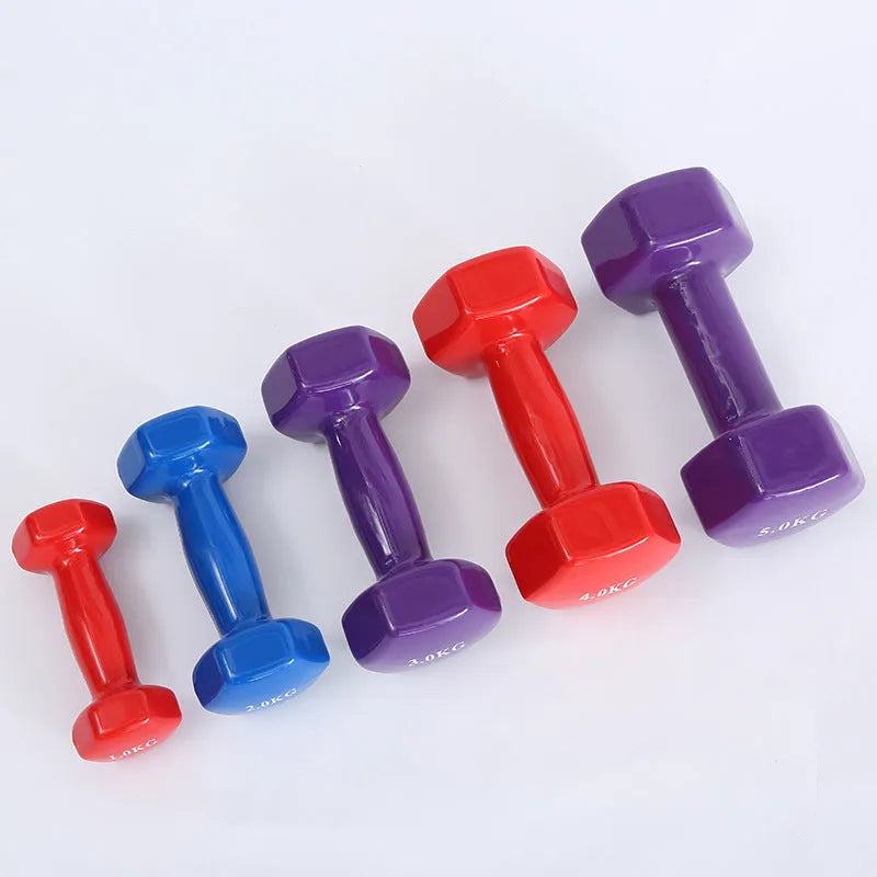 A set of bright red, blue, and green plastic fitness dumbbells with glossy finish on a wooden floor.