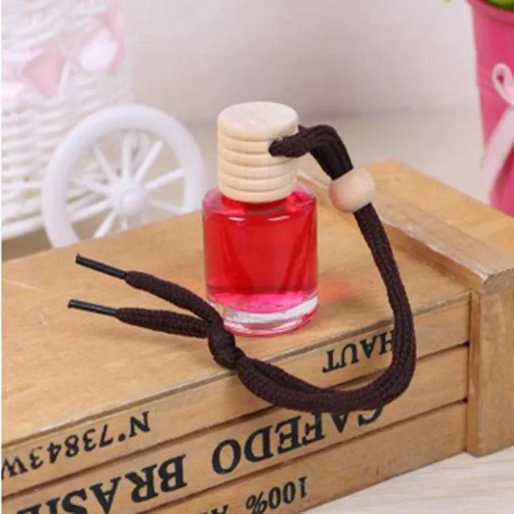 Car air freshener glass bottle hanging ornament showing scent options: Lavender, Lemon, Apple, Strawberry, Ocean, Floral.