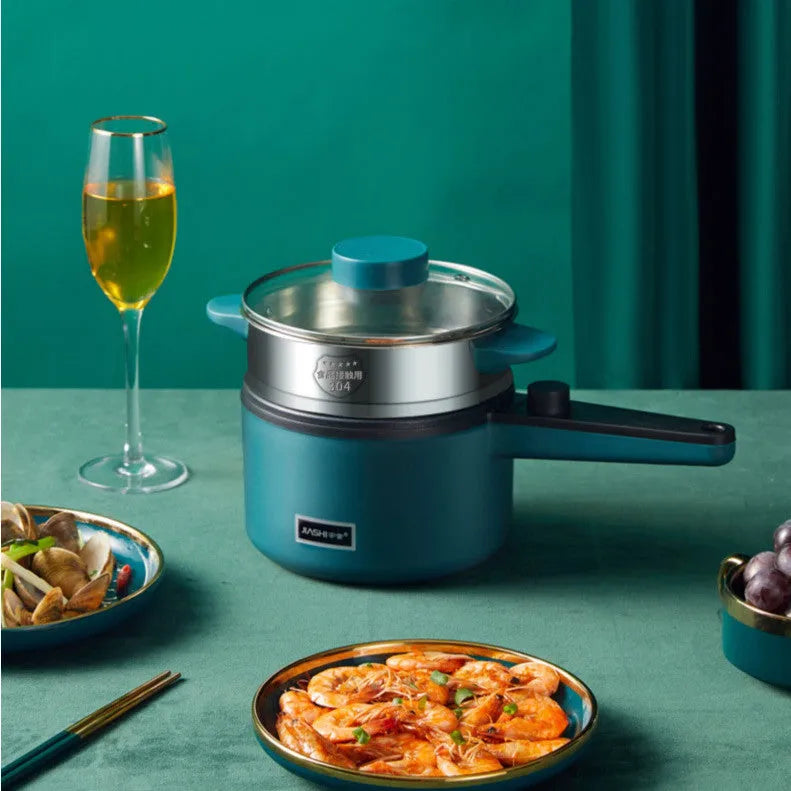 Nordic green mini electric pot with lid and steamer on countertop