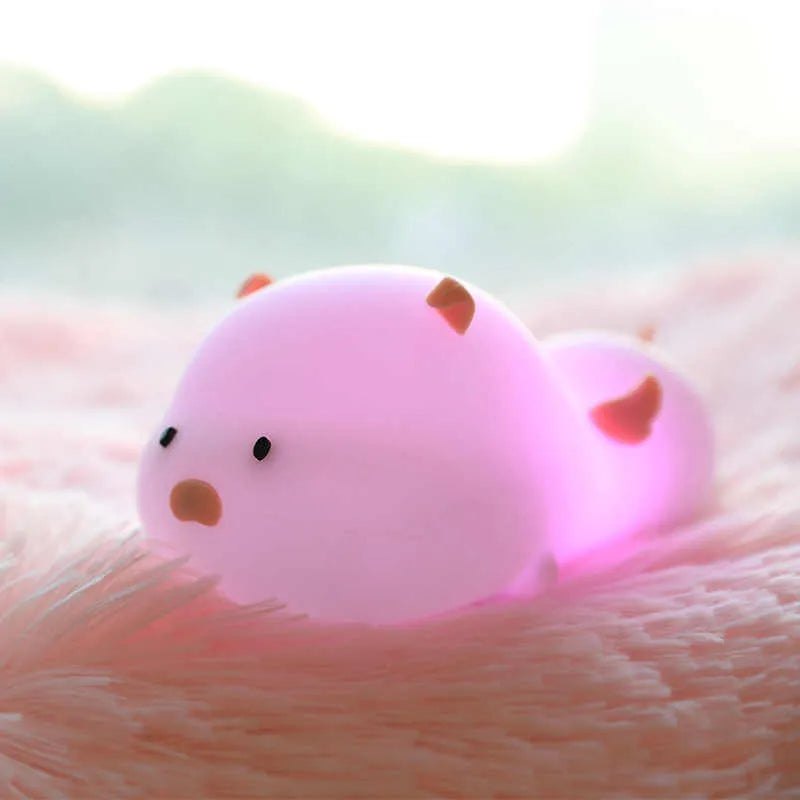 Blue silicone pig-shaped night light with USB charging port