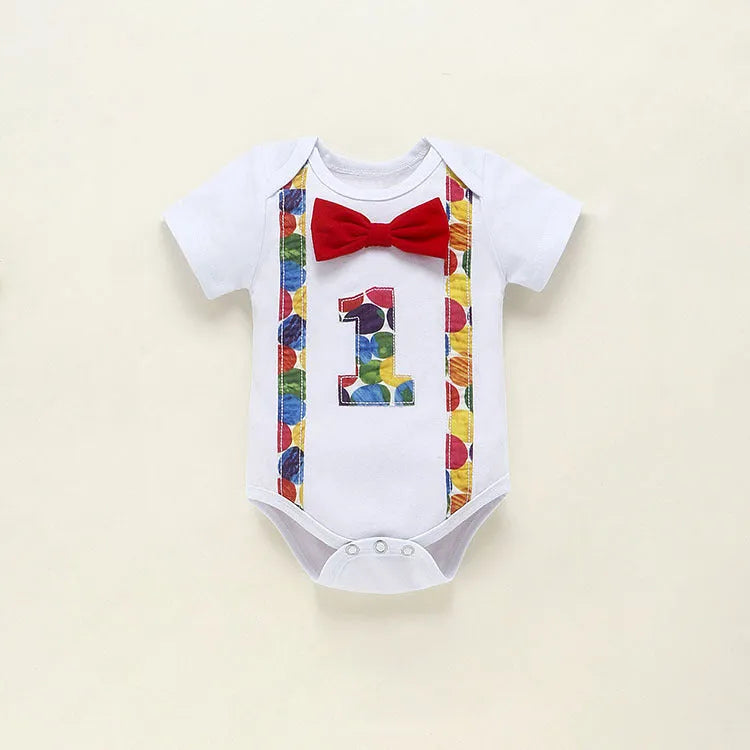 Baby or toddler wearing a soft cotton summer romper overall with shorts, in a choice of dinosaur or polka dot print colours.