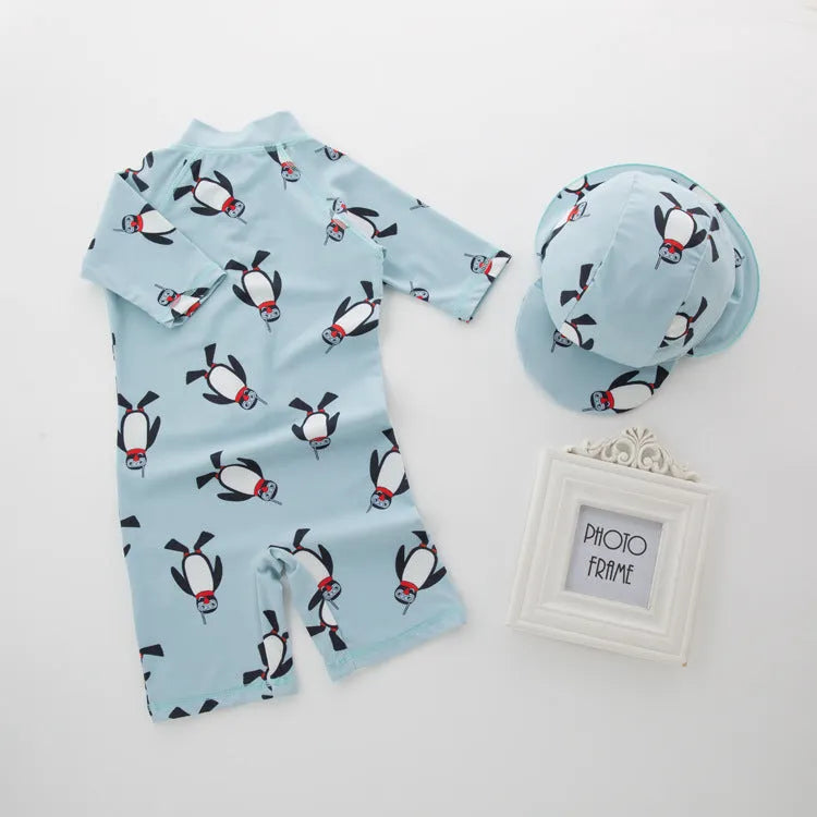 Boy's long sleeve penguin print swimsuit and matching swim cap set on a white background