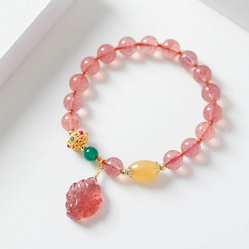 Women's Nine Tail Fox style strawberry quartz crystal beaded bracelet on wrist.