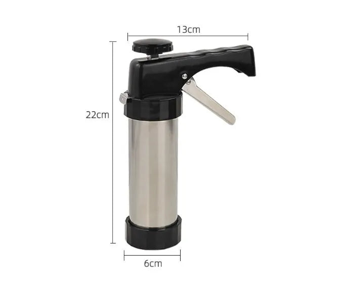 Stainless steel biscuit press gun with assortment of cookie moulds and piping nozzles on a baking sheet.