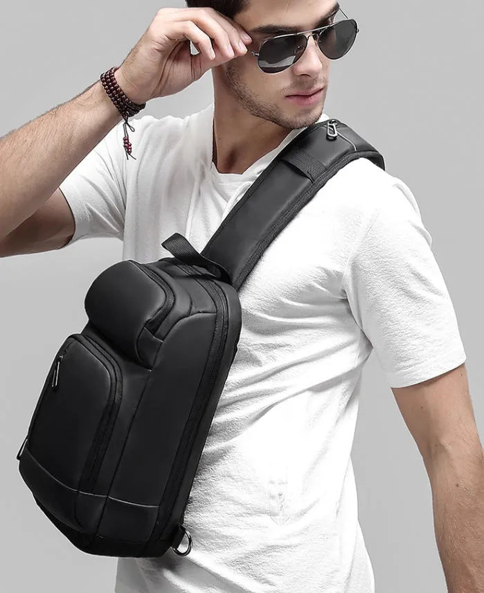 Black PVC outdoor shoulder bag with adjustable strap and internal laptop compartment