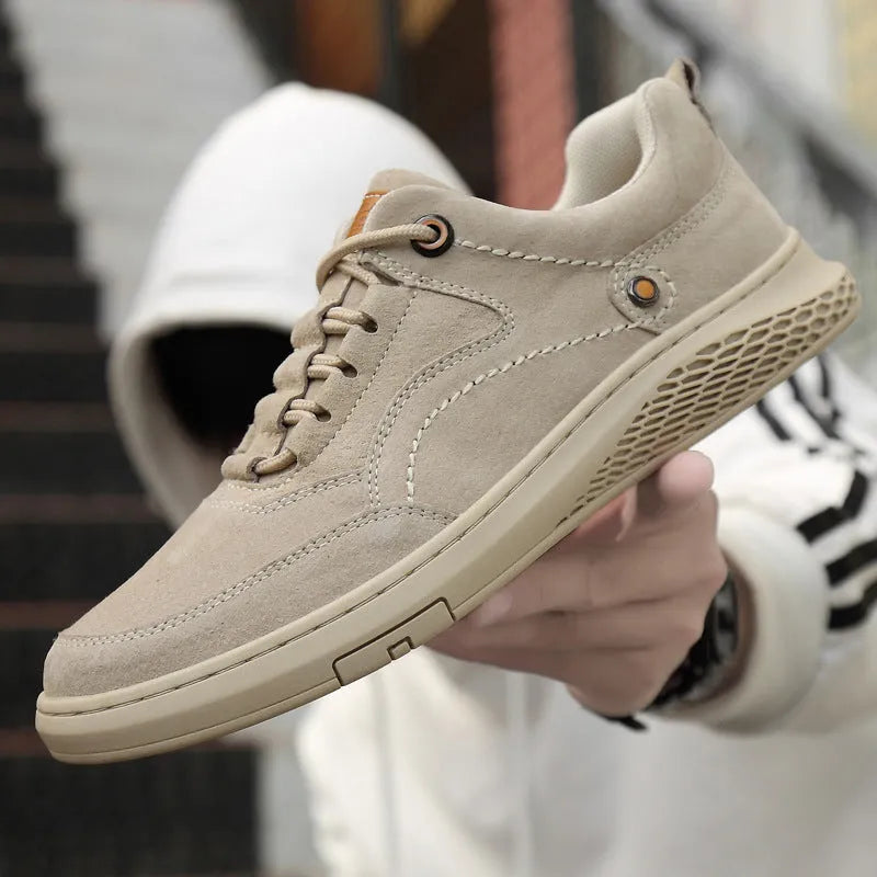 Men's brown leather sports shoes with suede finish and anti-skid plastic sole on concrete background