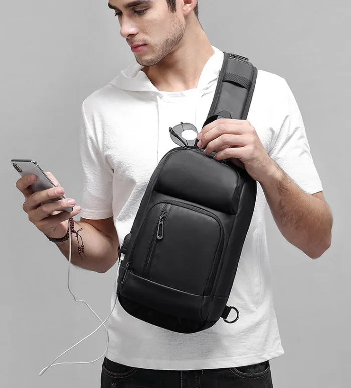 Black PVC outdoor shoulder bag with adjustable strap and internal laptop compartment