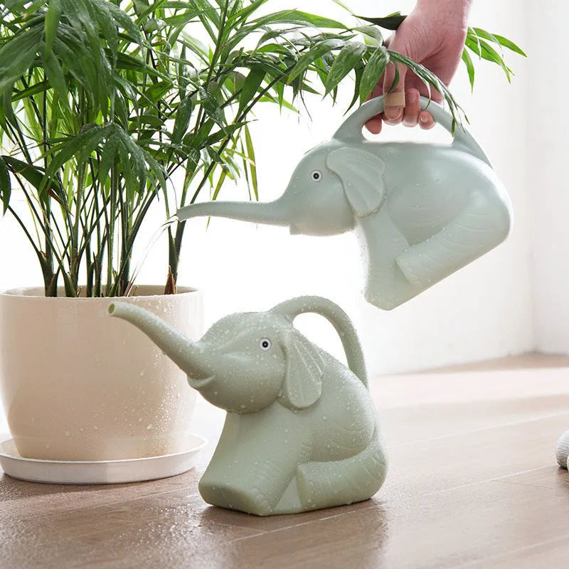 Pink children's watering can shaped like a sitting elephant with a long nozzle and bottle-shaped handle.