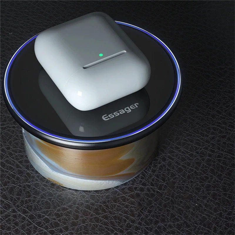 Black wireless charging pad on table with phone charging and blue LED indicator light