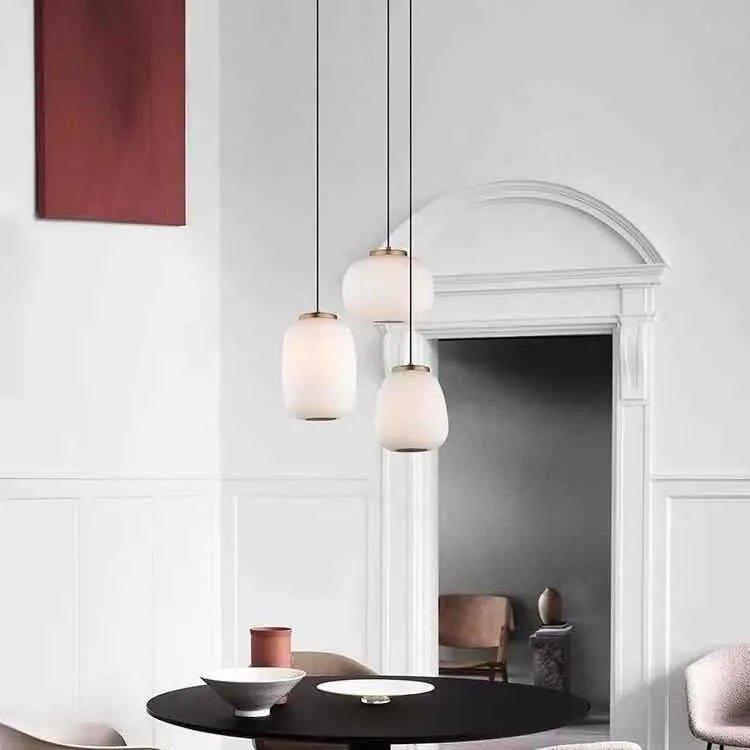 Modern minimalist long chandelier with iron frame and glass elements emitting warm LED light in a living room