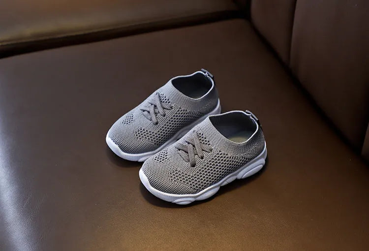 Children's white lazy slip-on shoe with fabric upper and textured non-slip rubber sole.