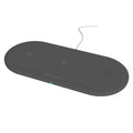 Black and white three-in-one wireless charging station for Apple iPhone, iWatch and headphones on a desk.