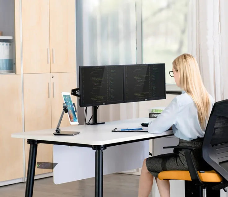 Folding aluminium desktop stand holding a tablet, showing its 360-degree rotation hinge and black/silver colour options.