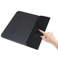 Grey foldable cloth phone holder open in stand mode, wirelessly charging a smartphone.