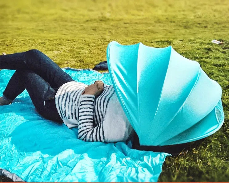 Outdoor sunproof fold beach umbrella with blue Lycra and mesh canopy on sandy beach